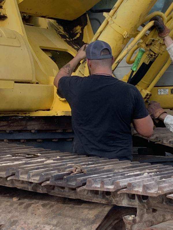 Forklift lifting tractor chassis during engine rebuild